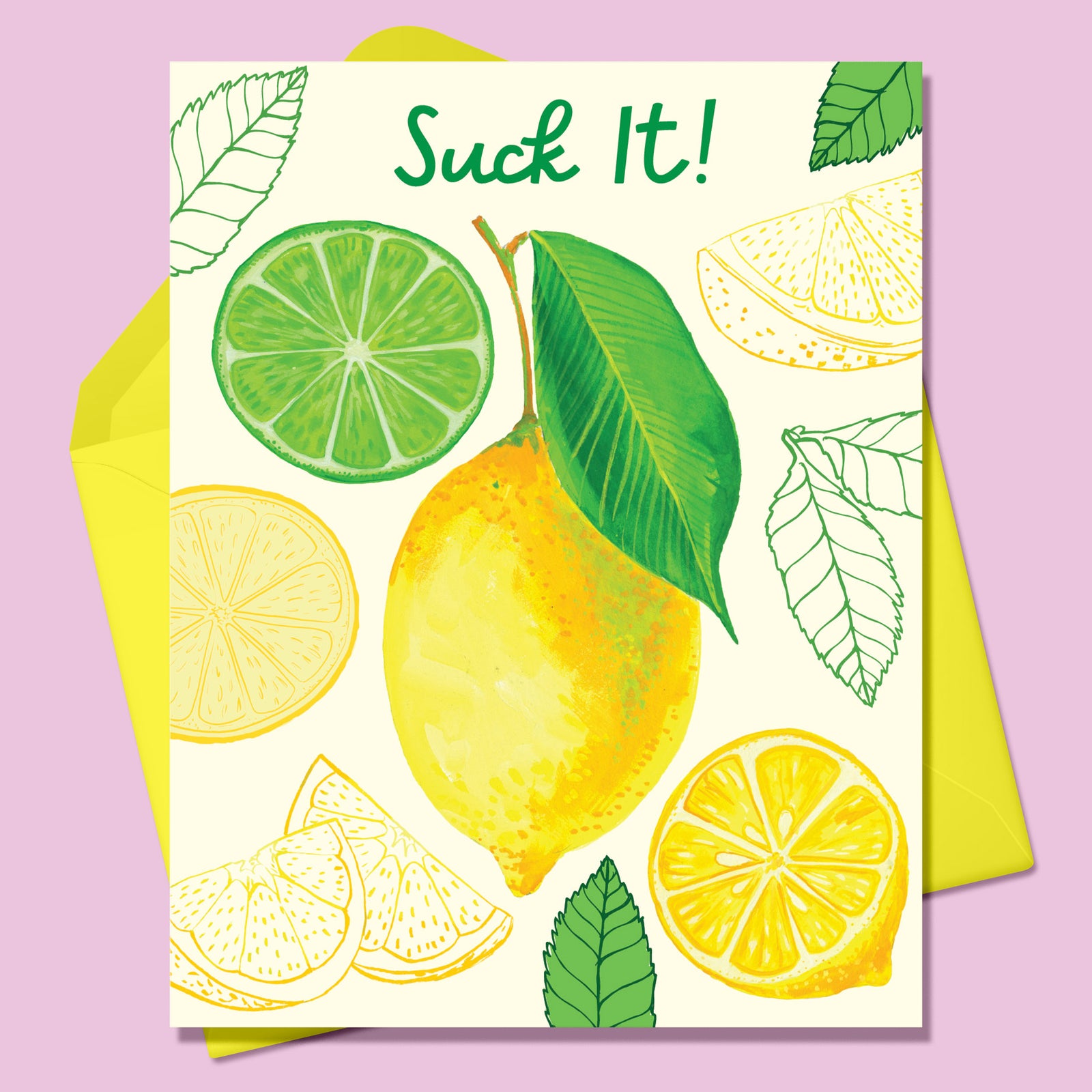 Paper Greeting card with the image of various lemons- a whole lemon in the center surrounded by cut lemons and green leaves and one cut lime  on a cream background. Text says Suck It! With a yellow envelope. On a lavender background.