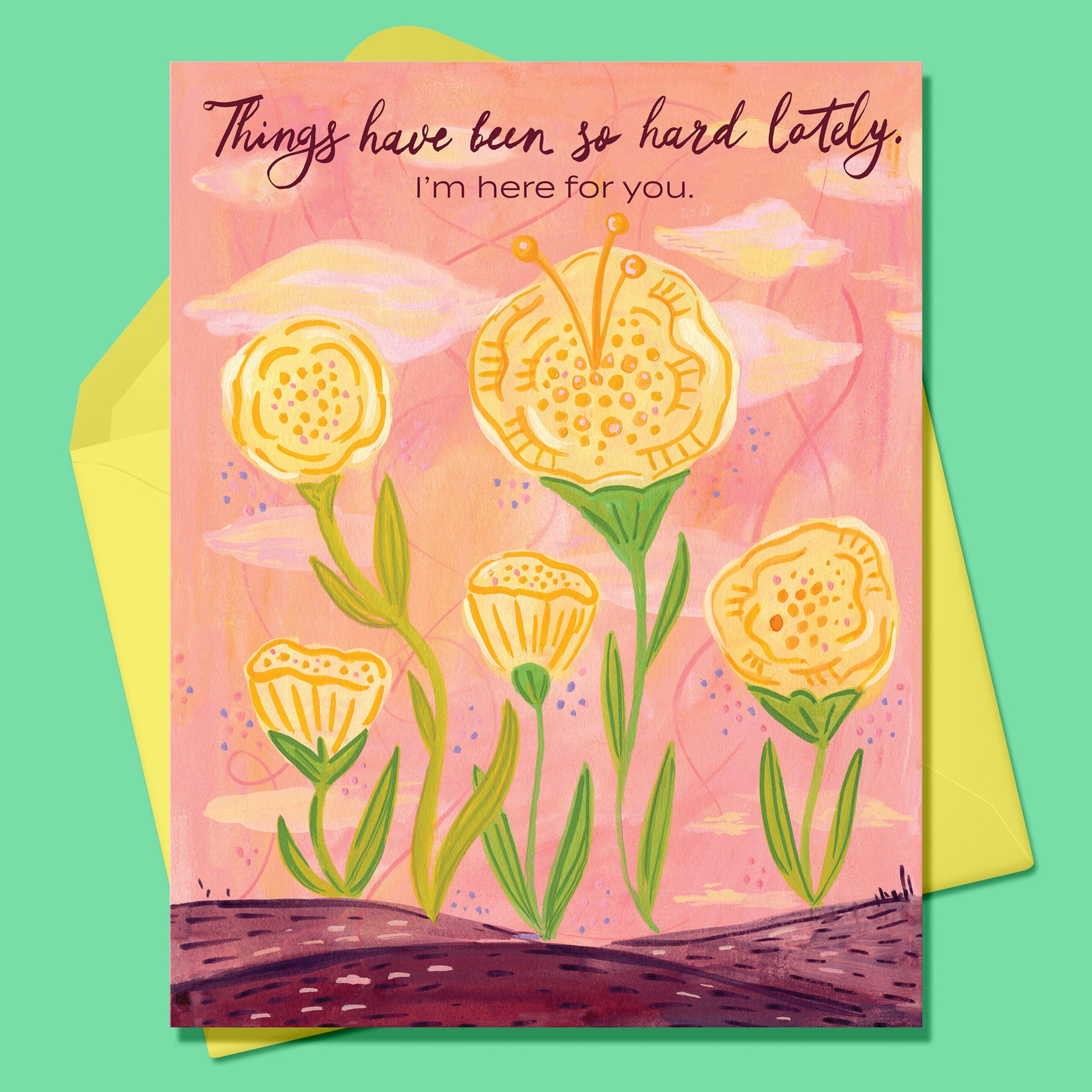 Paper Greeting card with 5 yellow flowers and green stems. Text says Things have been so hard lately. I'm here for you. Yellow envelope on a dark mint background.