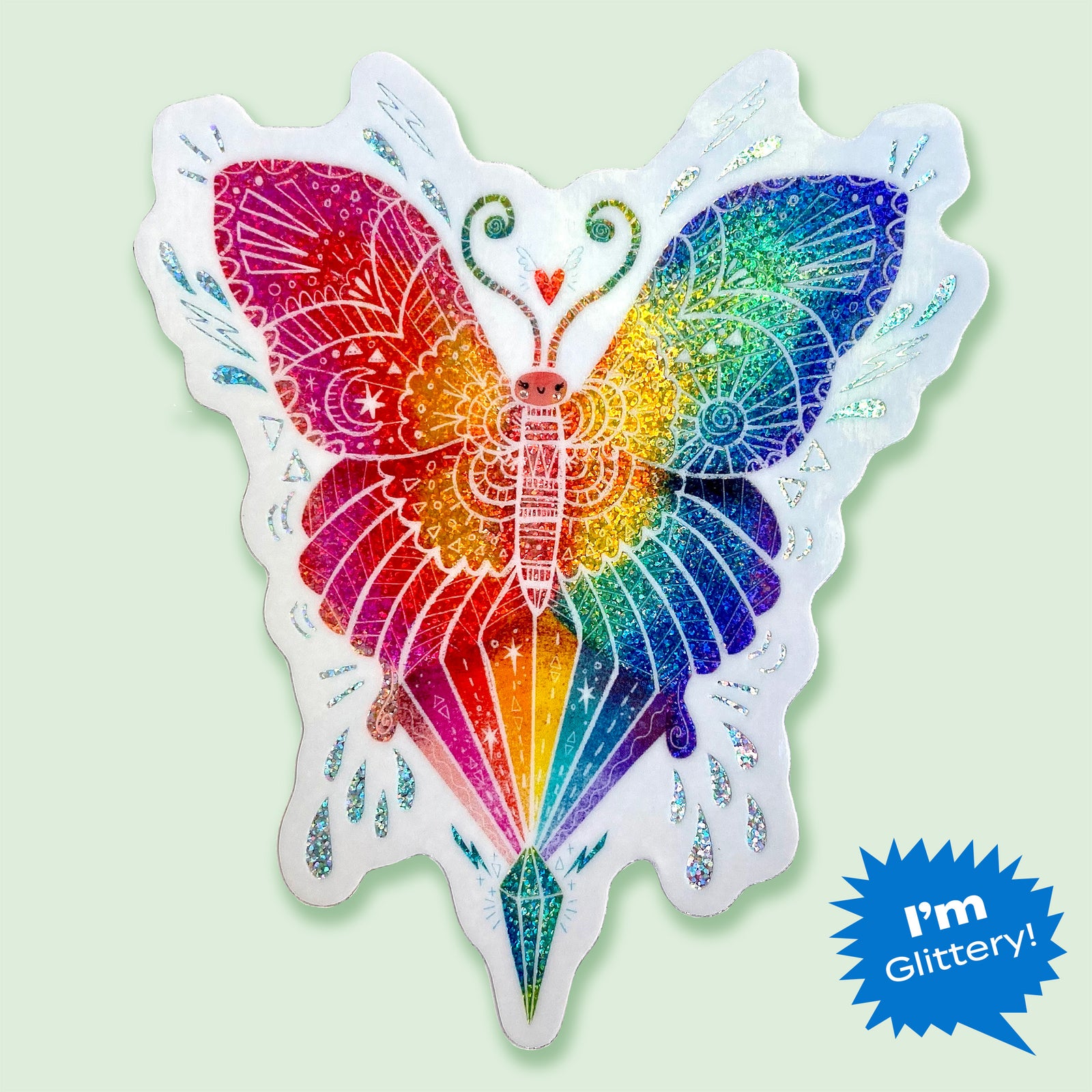 Butterfly shaped rainbow glitter sticker with white outline on a mint green background.
